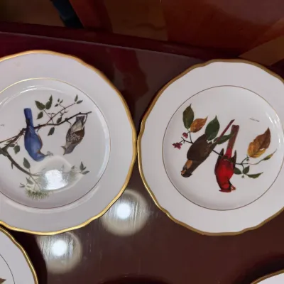 Sale Photo Thumbnail #213: Pair of porcelain collector plates featuring bird illustrations with scalloped, gold-rimmed edges.
