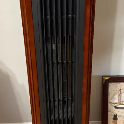Sale Photo Thumbnail #23: Tall electric space heater housed in a cherry-finished wooden cabinet, featuring a digital display panel and vertical front louvers.