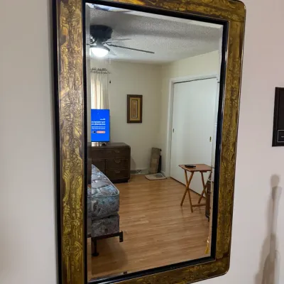 Sale Photo Thumbnail #102: Large mid-century modern wall mirror featuring a decorative gold and black textured frame with rounded corners.