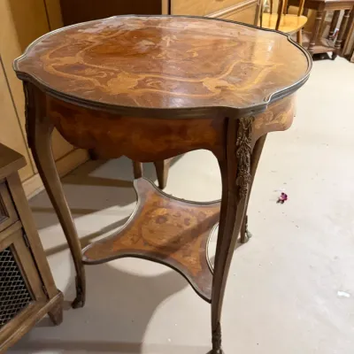 Sale Photo Thumbnail #386: French Provincial style marquetry inlay side table featuring cabriole legs, ornate brass or bronze mounts, and a lower tier shelf.