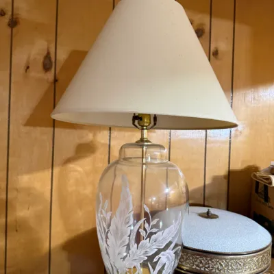 Sale Photo Thumbnail #390: Vintage table lamp featuring a clear glass ginger jar base with frosted botanical leaf etchings, a brass pedestal, and an off-white conical lampshade.