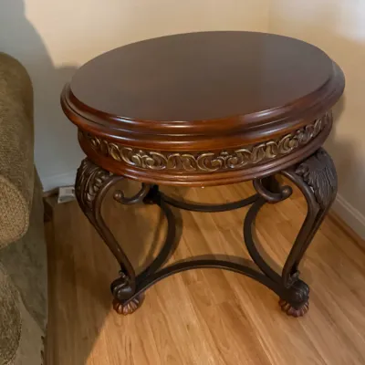 Sale Photo Thumbnail #83: Traditional oval wood accent table with carved leaf details, decorative apron moulding, and curved metal-style legs.
