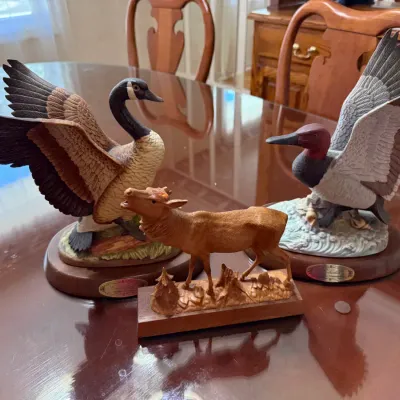Sale Photo Thumbnail #278: Trio of wildlife figurines, including two painted waterfowl on wooden bases and a carved wooden elk sculpture.