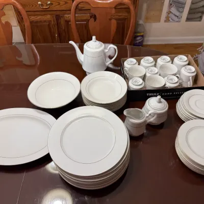 Sale Photo Thumbnail #298: Vintage white fine china dinnerware set with gold rim, including service plates, serving platter, teacups, teapot, and cream and sugar set.