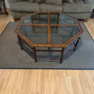 Sale Photo Thumbnail #319: Octagonal faux bamboo coffee table featuring a glass insert top with cross pane detailing, set over a geometric patterned area rug.