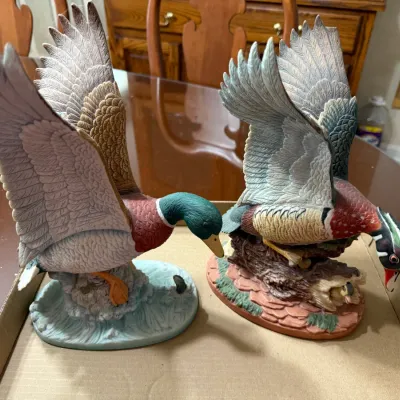 Sale Photo Thumbnail #241: Pair of detailed hand-painted porcelain duck figurines, depicting a mallard and a wood duck with outstretched wings.