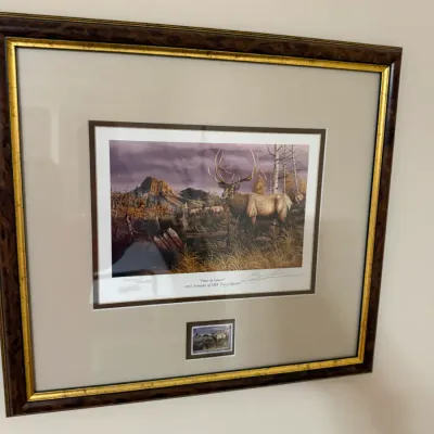 Sale Photo Thumbnail #367: Framed 1997 Friends of NRA limited-edition print titled "Time to Leave" depicting an elk in a mountain landscape, professionally matted with a matching stamp graphic.