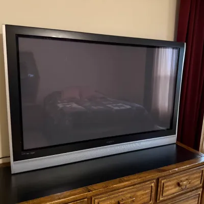Sale Photo Thumbnail #119: Vintage Sony WEGA flat-screen television with a silver and black bezel, resting on a wooden dresser.