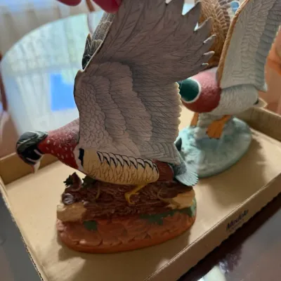 Sale Photo Thumbnail #244: Pair of hand-painted porcelain waterfowl figurines depicting a wood duck and a mallard duck in flight with wings spread.