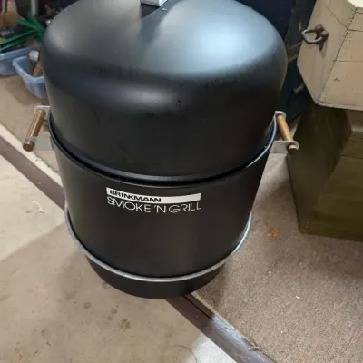 Brinkmann Smoke 'N Grill outdoor smoker with a matte black finish and wooden handles, appearing in good, lightly used condition.