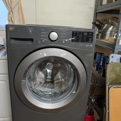 Modern LG front-load washing machine in a graphite steel finish with digital display panel.