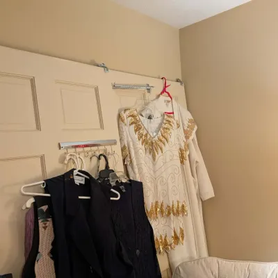 Selection of women's vintage clothing, including a white heavily sequins-and-bead embellished dress with gold accents alongside dark...
