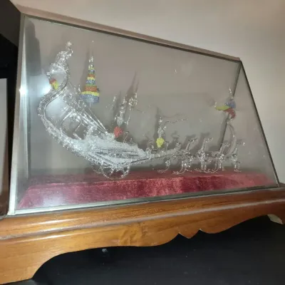 Intricately detailed spun glass Thai royal barge figure, housed in a glass and wooden display case with a red velvet base.