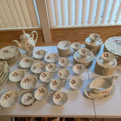 Large Rosenthal Moss Rose pattern porcelain dinnerware set, including teapot, teacups, saucers, bowls, and serving pieces with gilt trim.