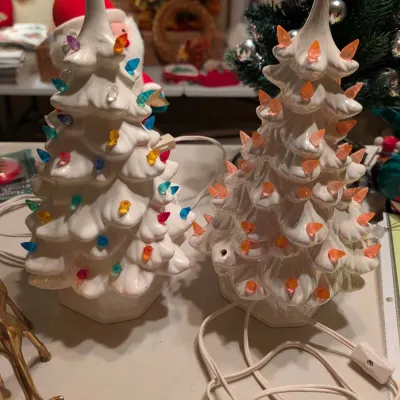 Pair of vintage white ceramic illuminated tabletop Christmas trees, one with multicolored plastic pegs and the other with orange pegs.