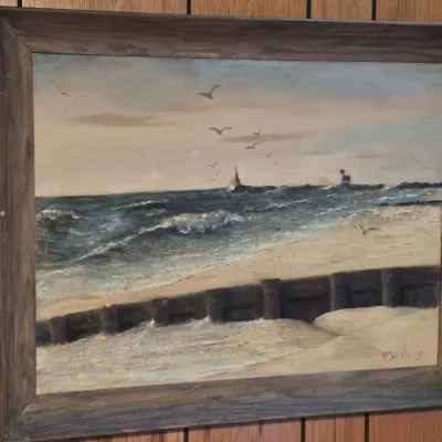 Framed coastal seascape oil painting depicting waves crashing on a sandy shore with seagulls and a distant lighthouse, signed P. Heritage...