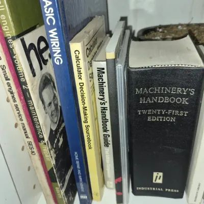 Collection of technical reference books and manuals, including Machinery's Handbook Twenty-First Edition and small engine repair...