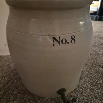 Vintage No. 8 stoneware crock dispenser featuring a grey salt-glazed finish and a bottom spigot.