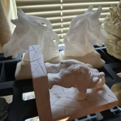 Collection of carved stone bookends, featuring a pair of alabaster horse head bookends and a carved elephant bookend.