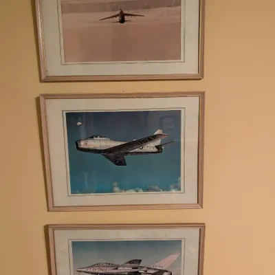 Set of three framed vintage U.S. Air Force aviation prints, each presented in matching light wood frames with off-white matting.