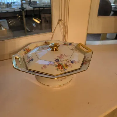 Vintage octagonal porcelain covered tureen featuring delicate floral motifs and gilt handles and finial.