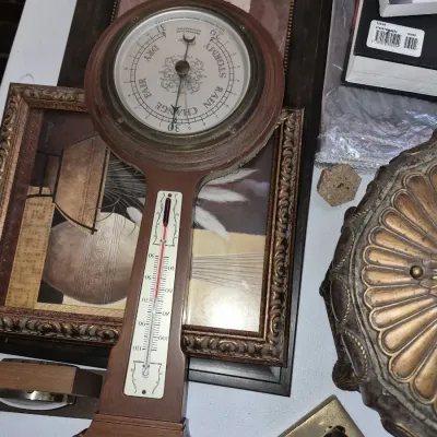 Vintage wooden banjo wall barometer featuring a main pressure dial, top hygrometer, and a built-in thermometer.