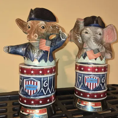 Pair of vintage 1976 Jim Beam ceramic bourbon decanters featuring a Democratic donkey and Republican elephant wearing Bicentennial...