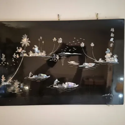 Vietnamese mother-of-pearl inlay black lacquer wall art panel depicting a rural river landscape with figures in boats.