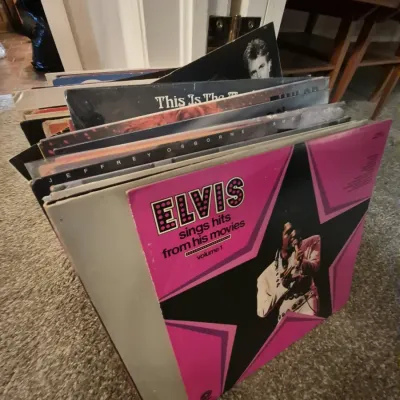 Collection of vintage vinyl LP records featuring artist albums including Elvis Presley's "Sings Hits From His Movies Volume...