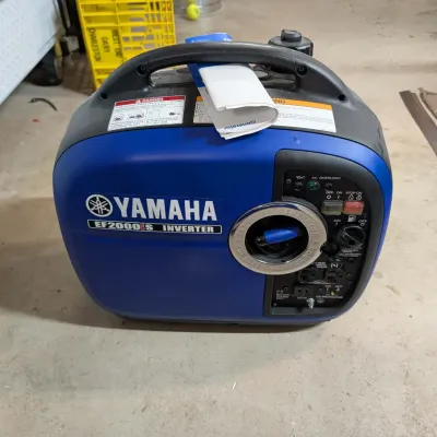 Yamaha EF2000iS portable inverter generator in blue and black, featuring a top carry handle and original manual.