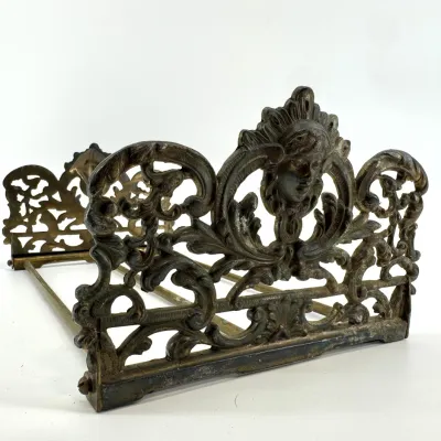 Sale Photo Thumbnail #6: Lot 5: Antique ornate brass expandable bookrack featuring a detailed face surrounded by  scrollwork.