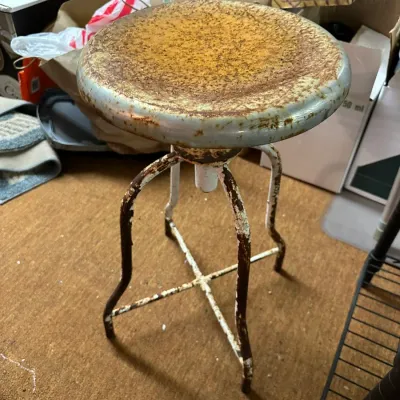 Sale Photo Thumbnail #323: Vintage industrial metal swivel stool with significant rust patina and original chipped paint finish.