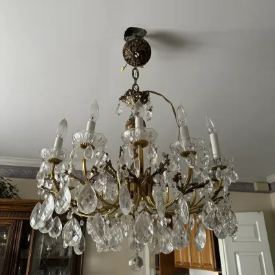 Sale Photo Thumbnail #454: Vintage brass multi-arm chandelier adorned with clear cut glass crystal drops and candle-style lights.