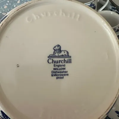 Sale Photo Thumbnail #707: Underside maker's mark of a Churchill England Blue Willow ceramic piece, featuring the lion emblem and product details.