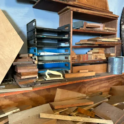 Sale Photo Thumbnail #512: Workshop shelf with stacked plastic letter trays, wooden storage cubbies, and various scrap lumber and tools.
