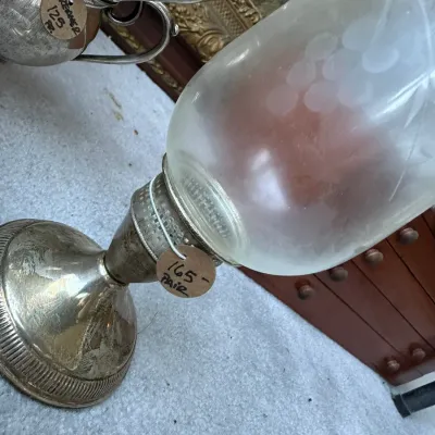 Sale Photo Thumbnail #403: Vintage silver-plated hurricane candleholder with etched glass shade featuring a grape motif, priced as a pair.