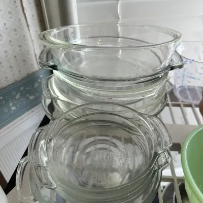Sale Photo Thumbnail #689: Stack of vintage clear Pyrex and glass baking dishes with handles in various sizes.