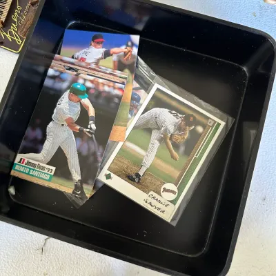 Sale Photo Thumbnail #384: Small collection of vintage 1990s baseball trading cards resting in a black plastic tray.