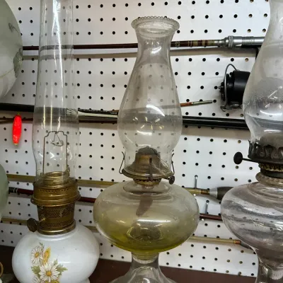 Sale Photo Thumbnail #43: Collection of vintage glass oil lamps, including a hand-painted floral base model and clear glass hurricane lamps.