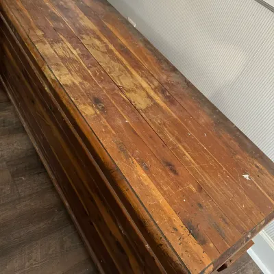 Sale Photo Thumbnail #347: Rustic wooden bench or chest top with heavily worn finish, visible scratches, and aged patina.