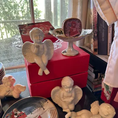 Sale Photo Thumbnail #683: Collection of holiday decorations, featuring small off-white cherub and angel figurines, a Santa Claus decorative plate, and a holiday compote dish.