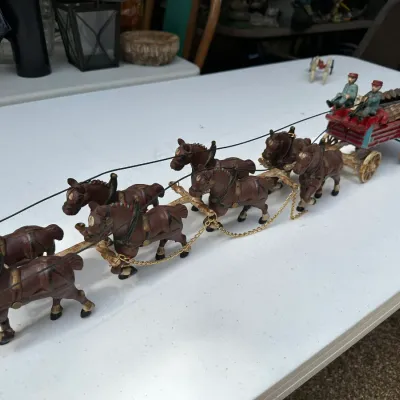 Sale Photo Thumbnail #172: Vintage cast iron eight-horse log wagon team with figures and wooden log load, displaying original paint and decorative chain harness details.