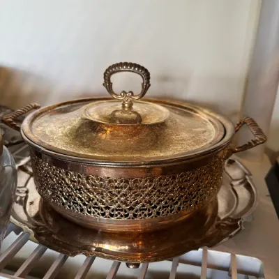 Sale Photo Thumbnail #679: Vintage silver-plated covered casserole dish with pierced reticulated holder, glass insert, and matching tray.