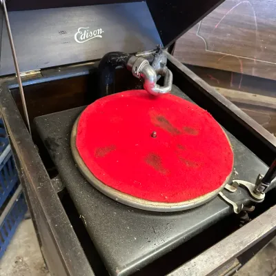 Sale Photo Thumbnail #518: Antique Edison Disc Phonograph housed in a dark wooden cabinet with a red felt turntable pad, displaying light cosmetic wear.