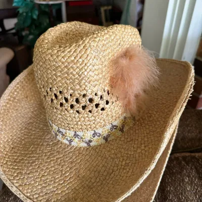 Sale Photo Thumbnail #635: Woven straw cowboy hat featuring a patterned band and a pink fur embellishment attached to the crown.