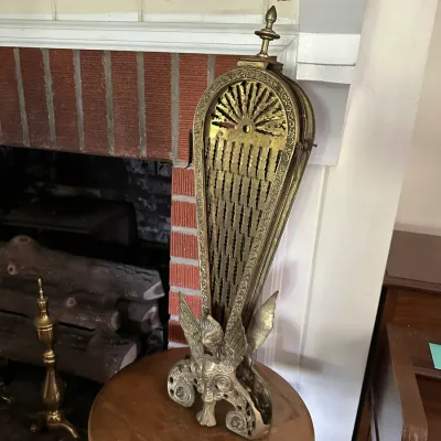 Sale Photo Thumbnail #652: Vintage ornate brass peacock fireplace screen with a winged gargoyle base and filigree detailing.