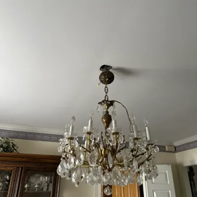 Sale Photo Thumbnail #453: Vintage brass multi-arm chandelier adorned with clear cut glass prisms and crystal teardrop pendants.
