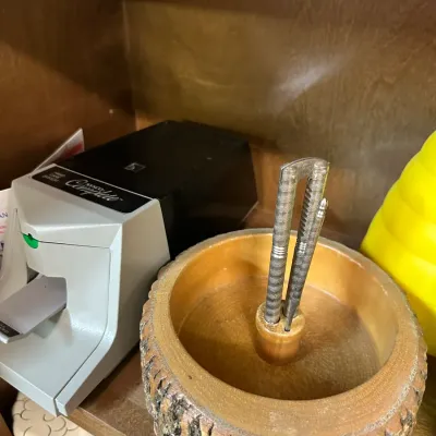 Sale Photo Thumbnail #62: Vintage live-edge natural log wood nutcracker bowl set with metal cracker tools, displayed next to a Sysco Complete electronic device on a cabinet shelf.