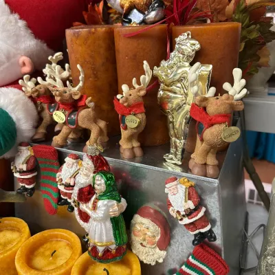 Sale Photo Thumbnail #17: Collection of Christmas holiday decorations, featuring reindeer figurines named Dancer, Cupid, and Prancer, Santa Claus ornaments, and pillar candles.