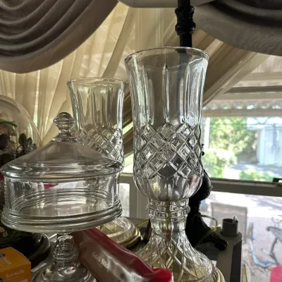 Sale Photo Thumbnail #655: Collection of clear cut glass glassware, including tall diamond-pattern hurricane lamp bases and a lidded pedestal candy dish.